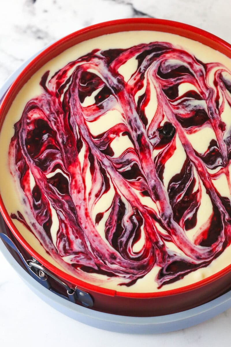 unbaked cheesecake with berry swirl on top