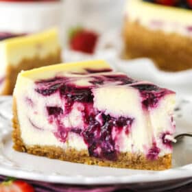 slice of triple berry cheesecake on white plate