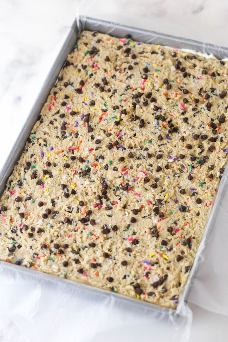 Brownie cookie dough ice cream sandwiches combine three favorites in one, with a few key ingredients to ensure they stay soft. Brownie cookie dough ice cream sandwiches in a pan