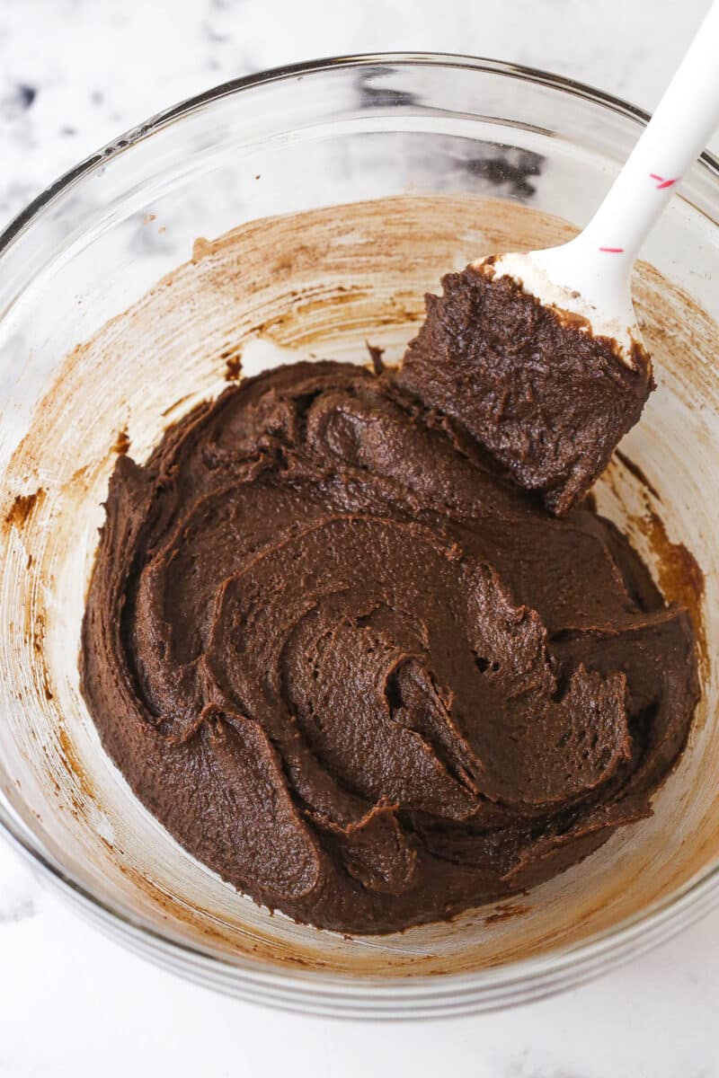 Brownie cookie dough ice cream sandwiches combine three favorites in one, with a few key ingredients to ensure they stay soft. Spatula stirring brownie batter
