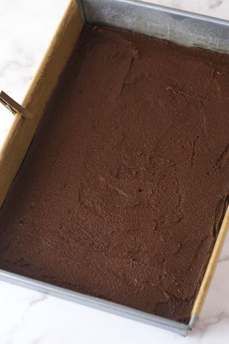 Brownie cookie dough ice cream sandwiches combine three favorites in one, with a few key ingredients to ensure they stay soft. Brownie batter spread in a pan