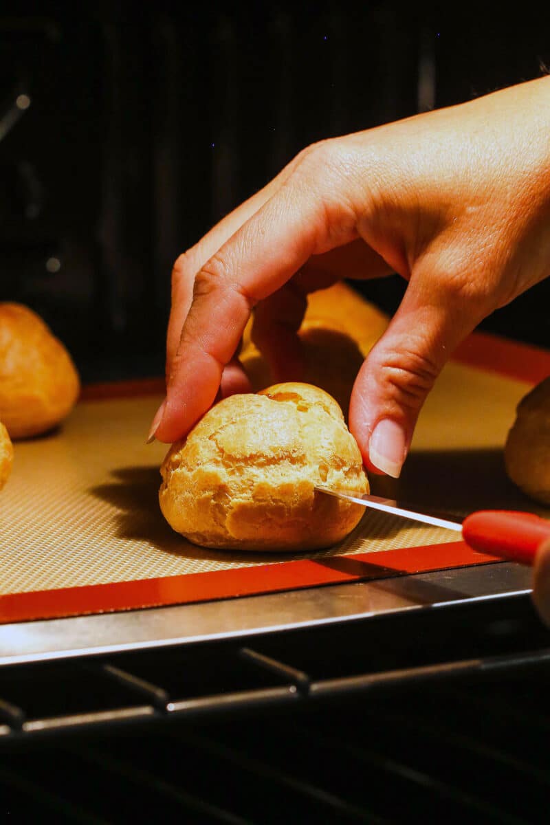 Master making cream puffs fit for a bakery and perfect for sharing with my in-depth tips and step-by-step photos. Poking a hole in a cream puff shell