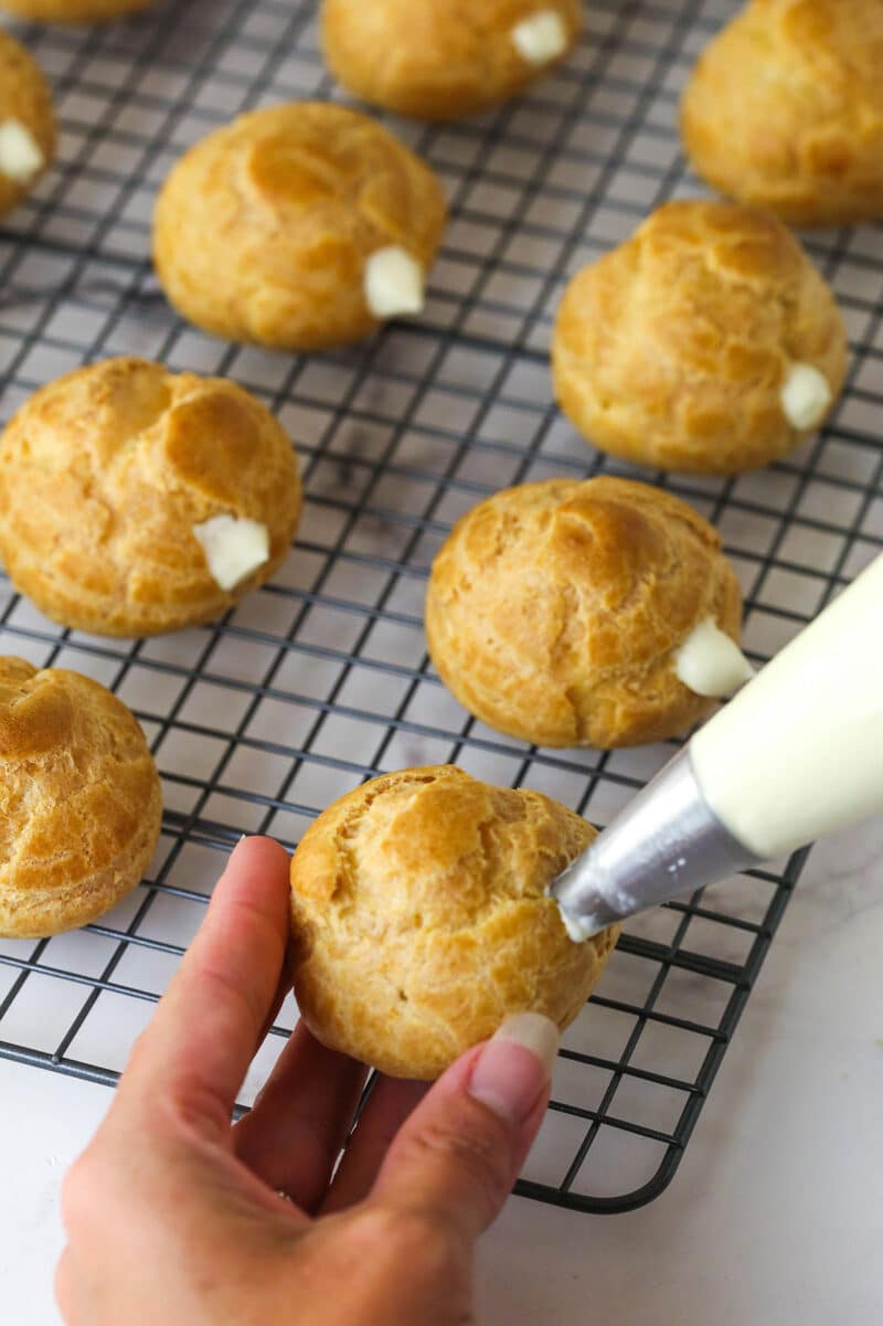 Master making cream puffs fit for a bakery and perfect for sharing with my in-depth tips and step-by-step photos. Piping whipped pastry cream into cream puffs