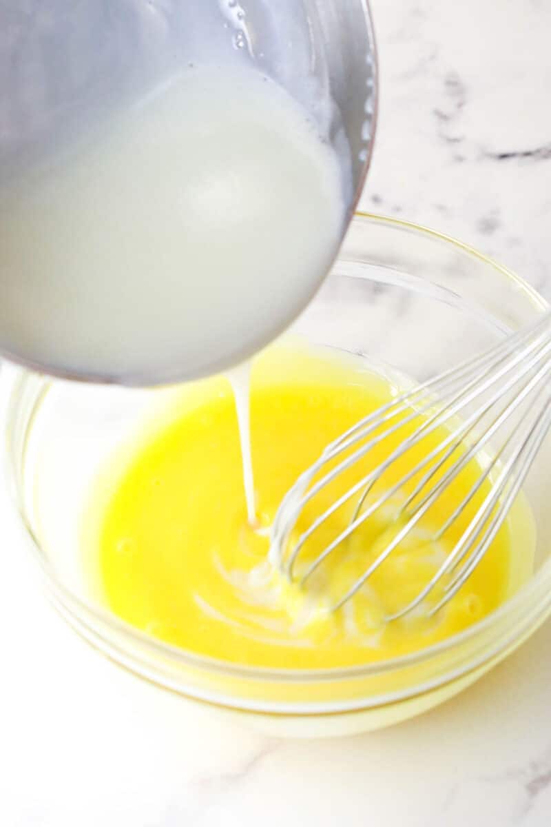 Master making cream puffs fit for a bakery and perfect for sharing with my in-depth tips and step-by-step photos. Tempering eggs with warm milk