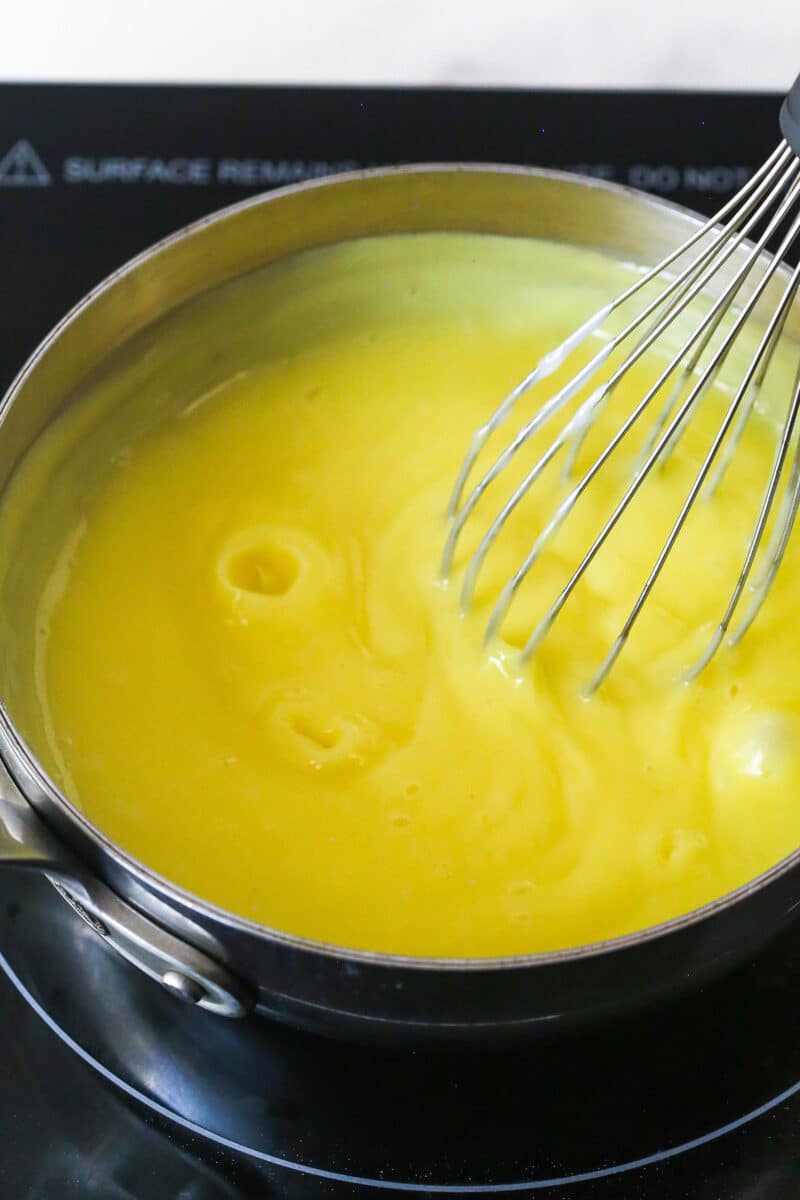 Master making cream puffs fit for a bakery and perfect for sharing with my in-depth tips and step-by-step photos. Custard simmering in a saucepan
