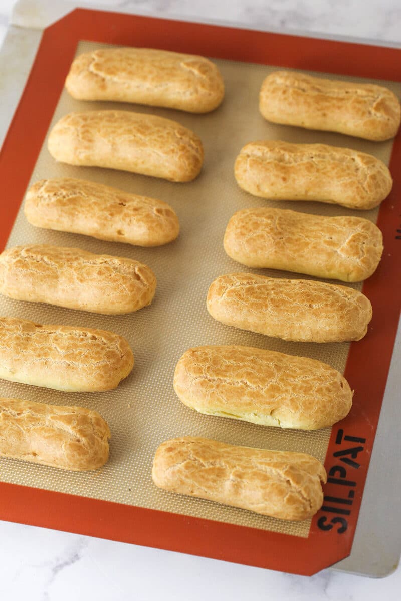 Eclair pastry shells on a baking sheet