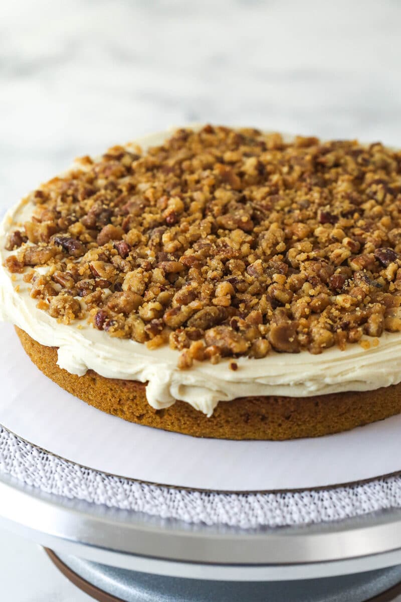 With layers of pumpkin cake, pecan praline crunch, and a caramel buttercream, this pecan praline pumpkin cake is impressive and delicious. A pumpkin cake topped with buttercream and praline crunch