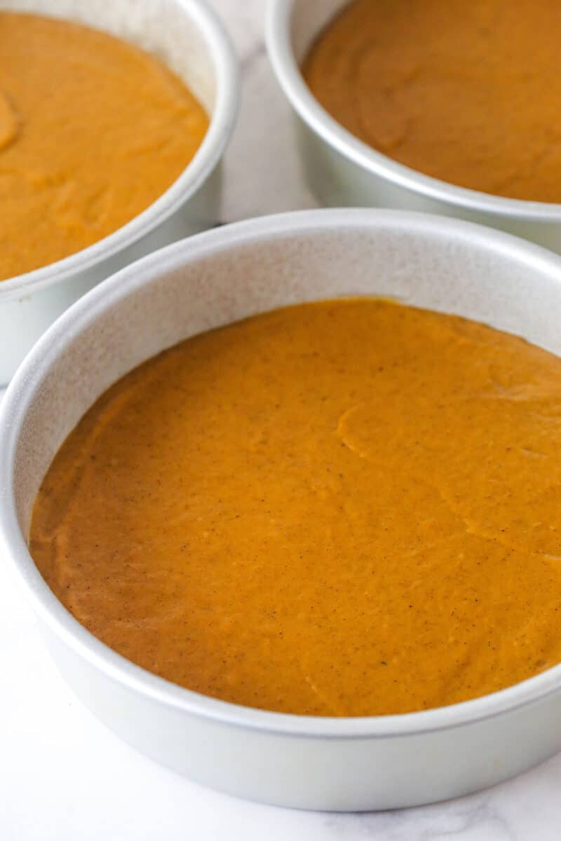 With layers of pumpkin cake, pecan praline crunch, and a caramel buttercream, this pecan praline pumpkin cake is impressive and delicious. Pumpkin cake batter in round pans