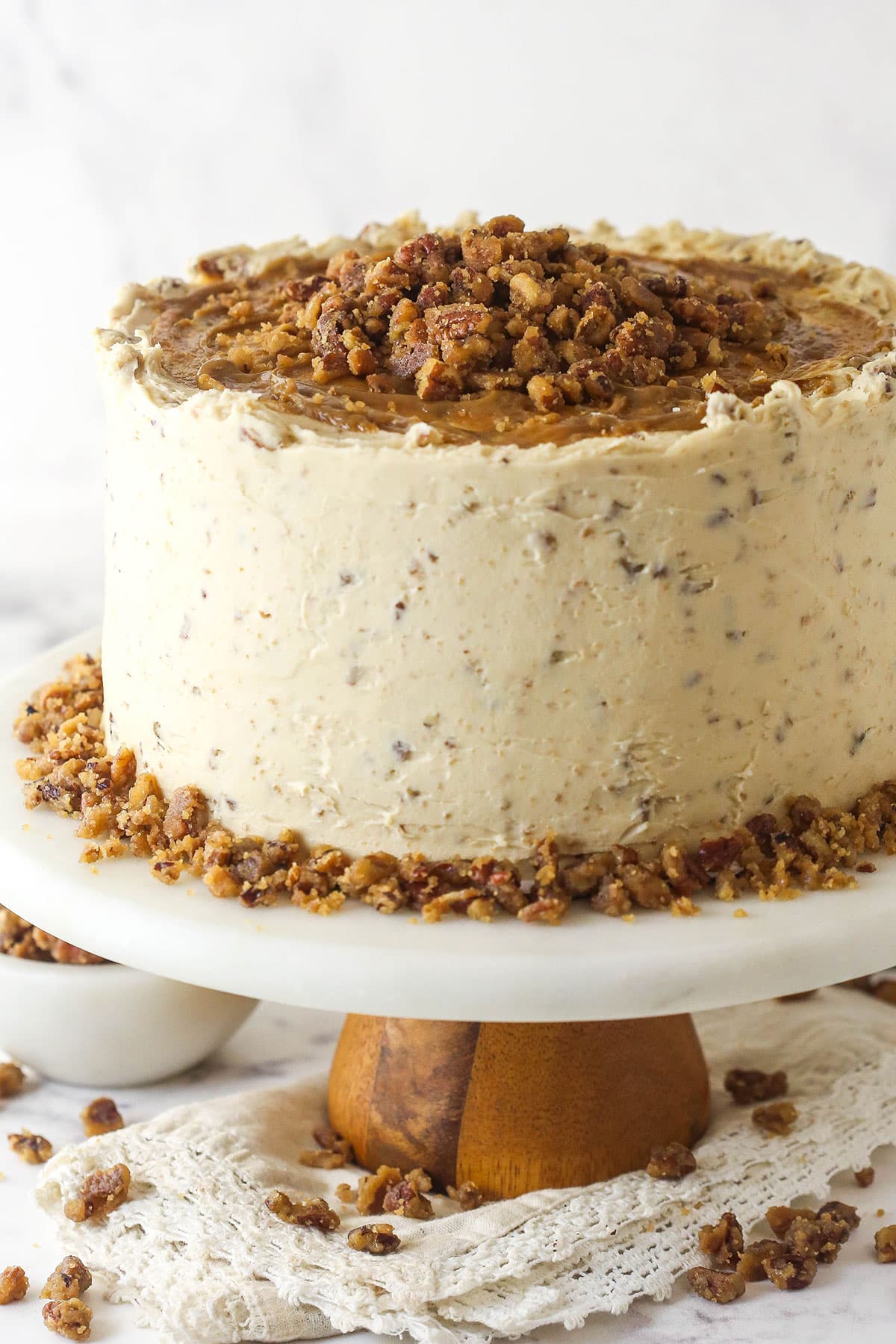 With layers of pumpkin cake, pecan praline crunch, and a caramel buttercream, this pecan praline pumpkin cake is impressive and delicious. A frosted pecan praline pumpkin cake