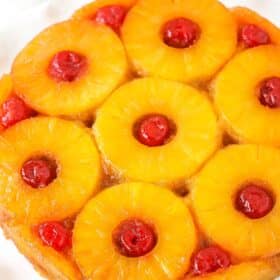 A pineapple upside down cake on a white platter.