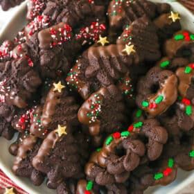 snowflake, christmas tree and wreath chocolate spritz cookies on white plate