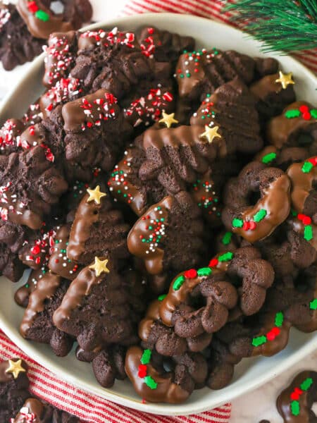 snowflake, christmas tree and wreath chocolate spritz cookies on white plate