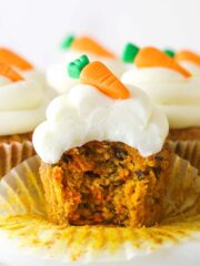 A carrot cake cupcake with a bite taken out of it.