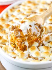A scoop of Loaded Sweet Potatoes being taken with a wooden spoon