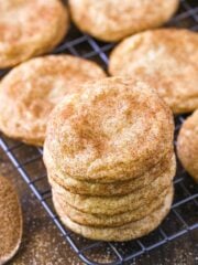 A stack of snickerdoodles on a wire rack.