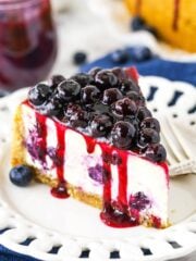 A Close-Up Shot of a Slice of Baked Blueberry Cheesecake with Blueberry Sauce on Top