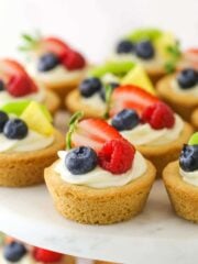 Easy fruit cheesecake sugar cookie cups arranged on a cake platter.