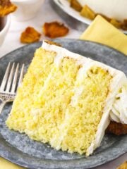A slice of pineapple layer cake on a plate with the remaining cake behind it